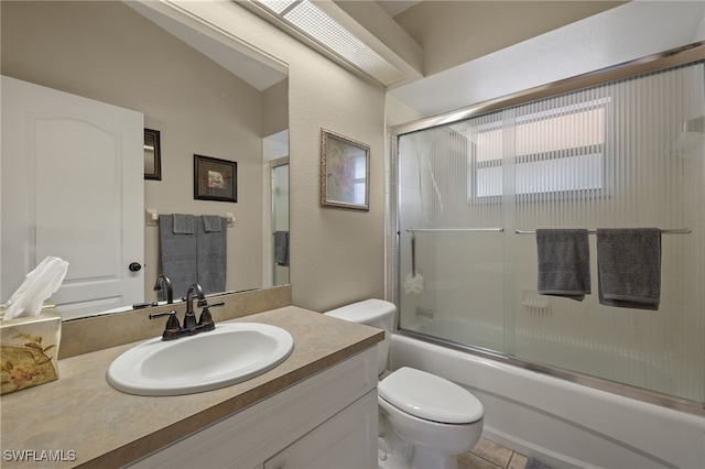 bathroom featuring tile patterned floors, vanity, toilet, and bath / shower combo with glass door