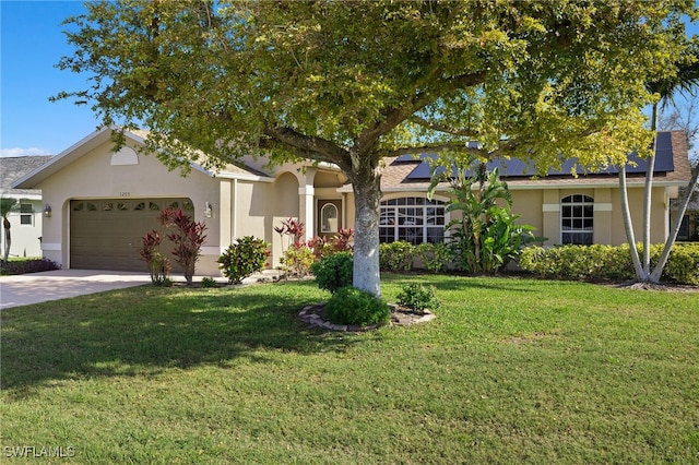 ranch-style house featuring stucco siding, an attached garage, roof mounted solar panels, driveway, and a front lawn