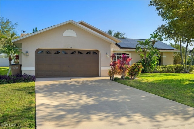 ranch-style home featuring an attached garage, concrete driveway, stucco siding, roof mounted solar panels, and a front yard