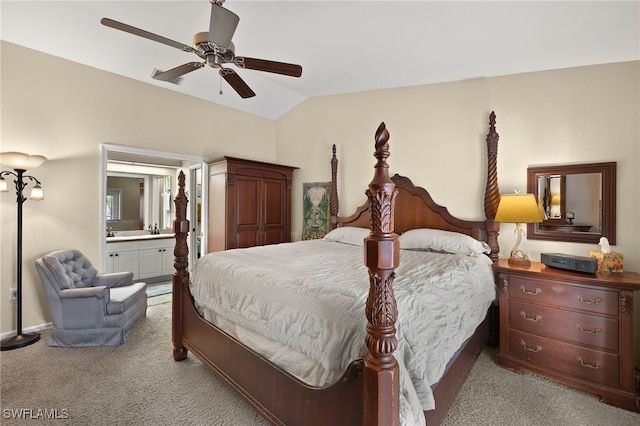 bedroom featuring vaulted ceiling, light carpet, connected bathroom, and a ceiling fan