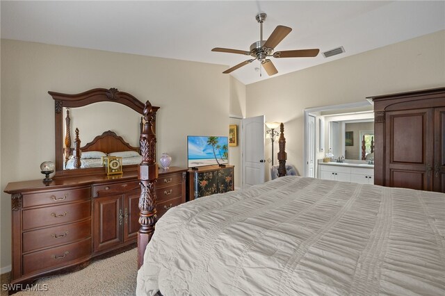 bedroom with light colored carpet, visible vents, vaulted ceiling, connected bathroom, and ceiling fan