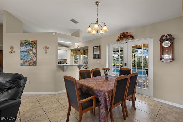 dining space with light tile patterned floors, visible vents, vaulted ceiling, and french doors