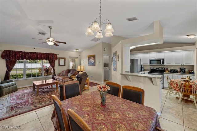 dining area with lofted ceiling, visible vents, and light tile patterned flooring