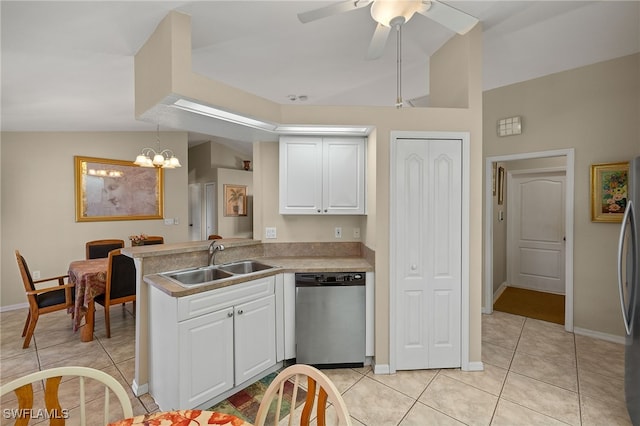 kitchen with appliances with stainless steel finishes, vaulted ceiling, white cabinets, and a sink