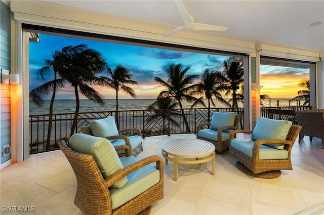 view of patio featuring a balcony, an outdoor living space, ceiling fan, and a water view