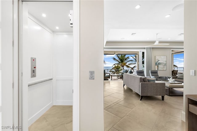 corridor featuring a decorative wall, elevator, recessed lighting, and light tile patterned floors