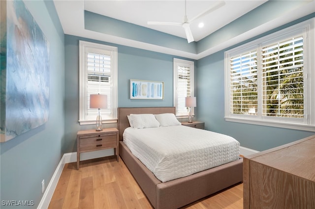 bedroom with light wood-type flooring, baseboards, and multiple windows