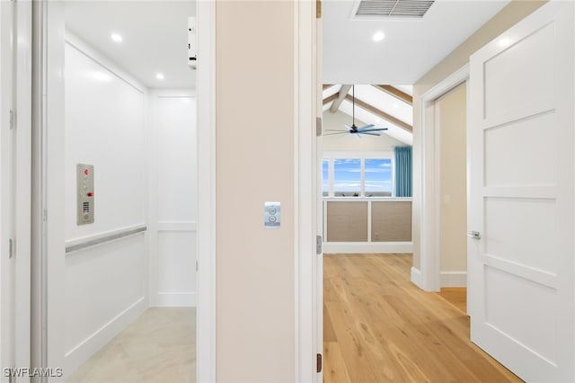 hallway with visible vents, light wood-style flooring, elevator, recessed lighting, and vaulted ceiling