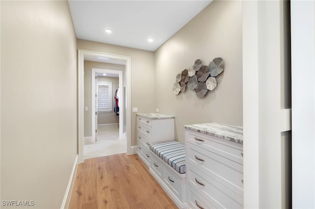 hall with recessed lighting, light wood-style floors, and baseboards