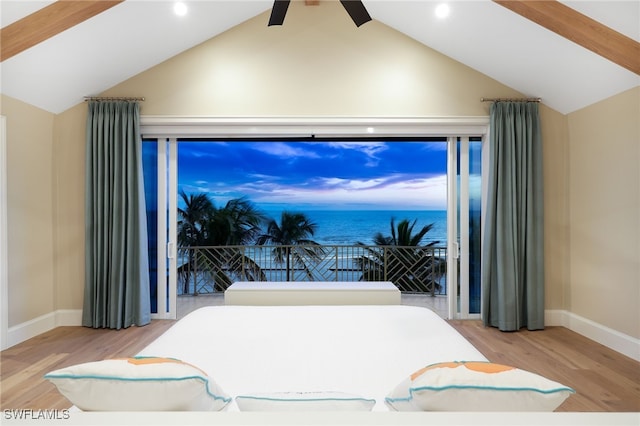 bedroom with vaulted ceiling with beams, wood finished floors, a water view, and baseboards