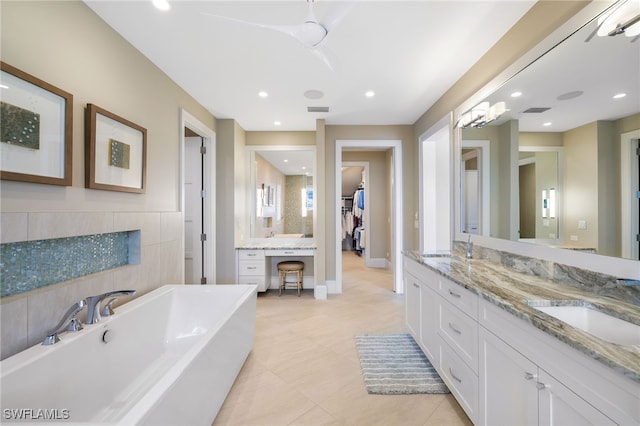 full bath featuring a freestanding bath, double vanity, recessed lighting, and a sink