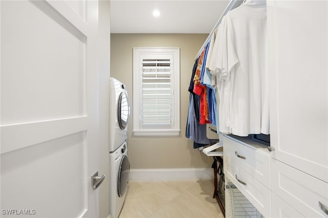 washroom featuring baseboards, stacked washer and dryer, light tile patterned floors, laundry area, and recessed lighting