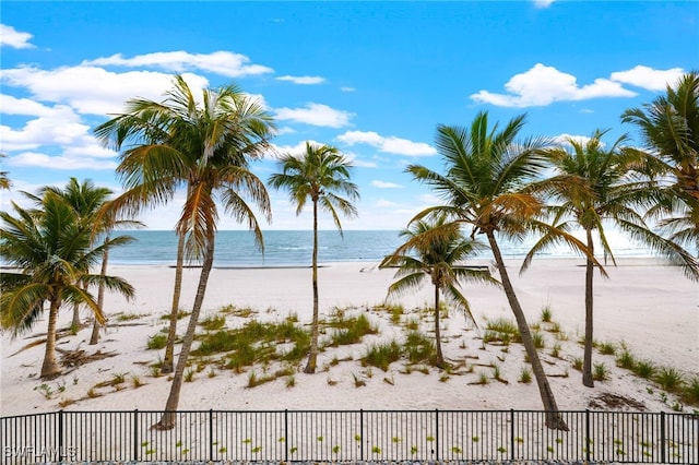 property view of water featuring a view of the beach and fence