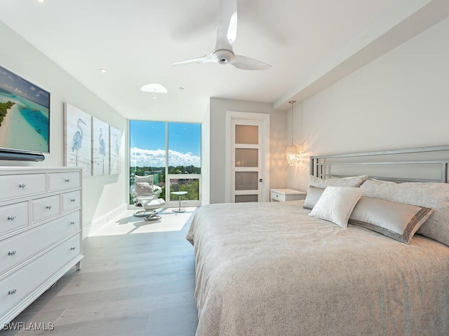 bedroom featuring access to exterior, floor to ceiling windows, ceiling fan, and wood finished floors