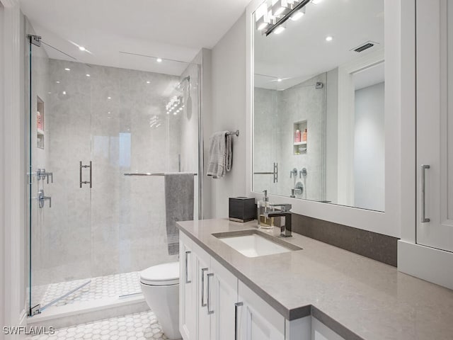 bathroom featuring visible vents, toilet, a stall shower, and vanity