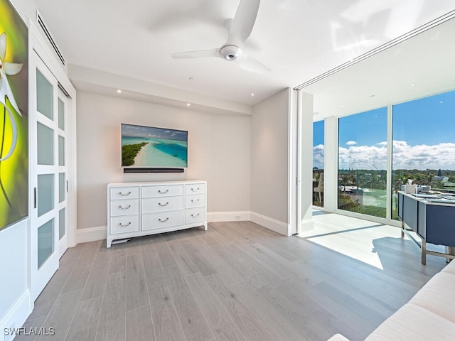 interior space featuring expansive windows, baseboards, and wood finished floors