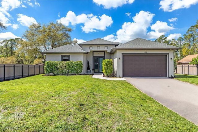 prairie-style home featuring fence, driveway, stucco siding, a front lawn, and a garage