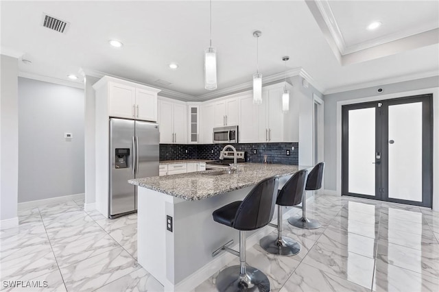 kitchen with stainless steel appliances, marble finish floor, a peninsula, and crown molding