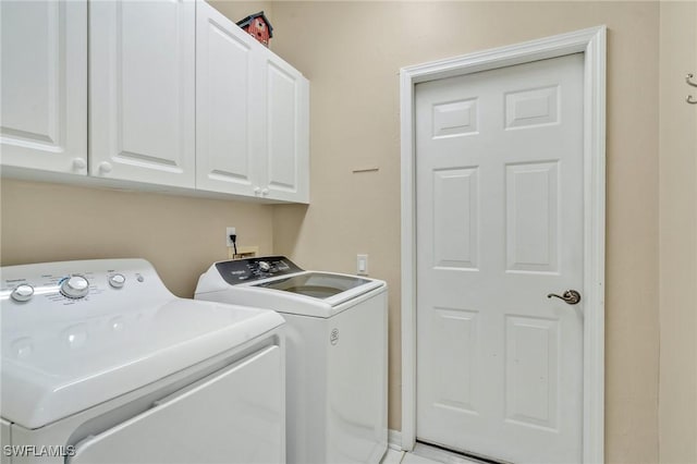 washroom with separate washer and dryer and cabinet space