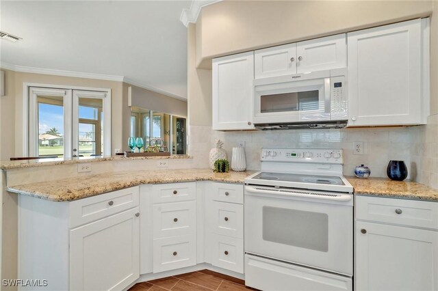 kitchen featuring a peninsula, white appliances, visible vents, backsplash, and crown molding