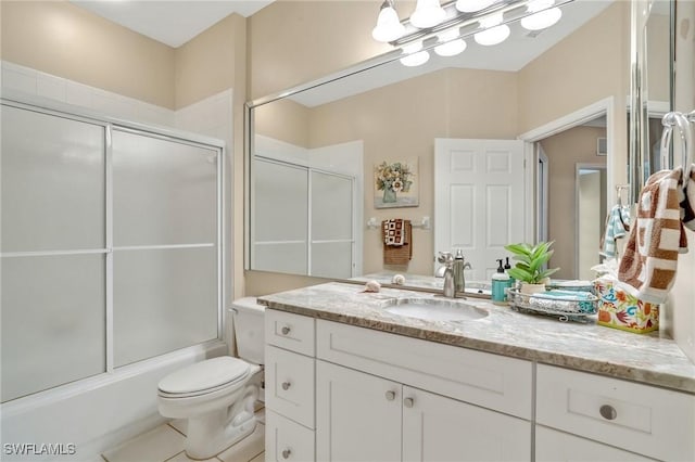 bathroom with toilet, combined bath / shower with glass door, and vanity