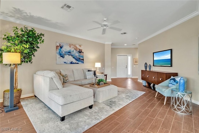 living room with wood tiled floor, visible vents, baseboards, and ornamental molding