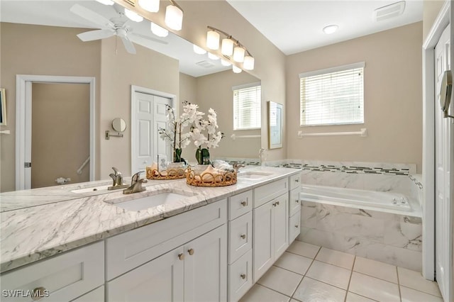 full bath featuring tile patterned flooring, a sink, a bath, and double vanity