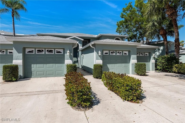 view of front of house featuring a garage, driveway, and stucco siding