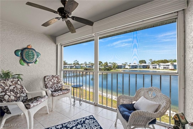 sunroom / solarium with ceiling fan, a water view, and a wealth of natural light