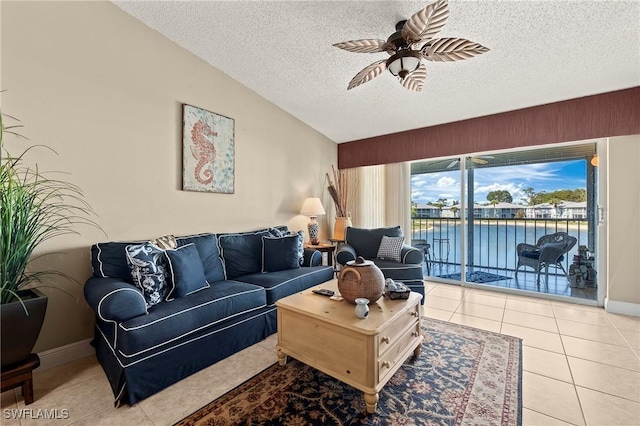 tiled living area featuring vaulted ceiling, a textured ceiling, a ceiling fan, and baseboards