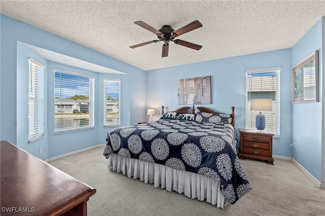 bedroom featuring a textured ceiling, multiple windows, carpet, and baseboards