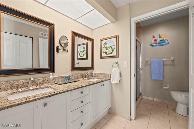 full bathroom featuring toilet, tile patterned flooring, visible vents, and a sink