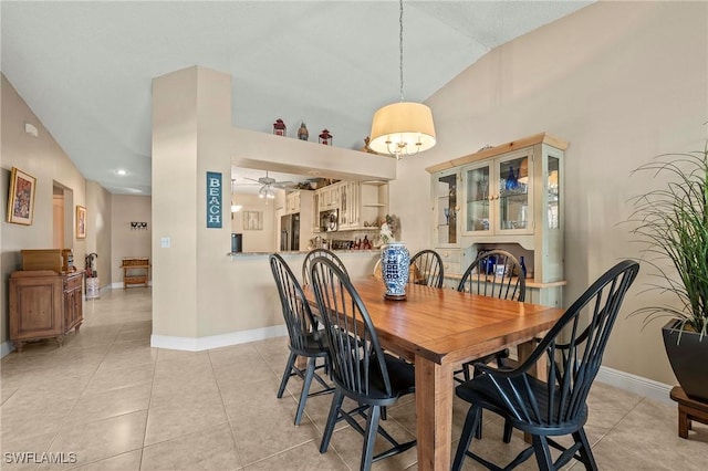 dining area with light tile patterned floors, a ceiling fan, and baseboards