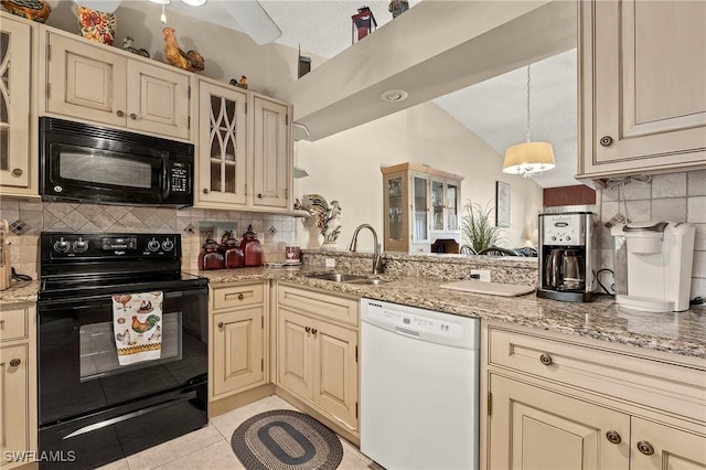 kitchen featuring light tile patterned flooring, a sink, cream cabinetry, black appliances, and tasteful backsplash