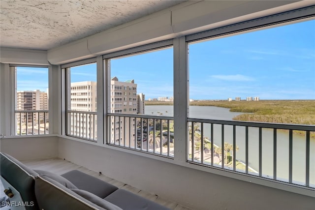 unfurnished sunroom featuring a view of city and a water view