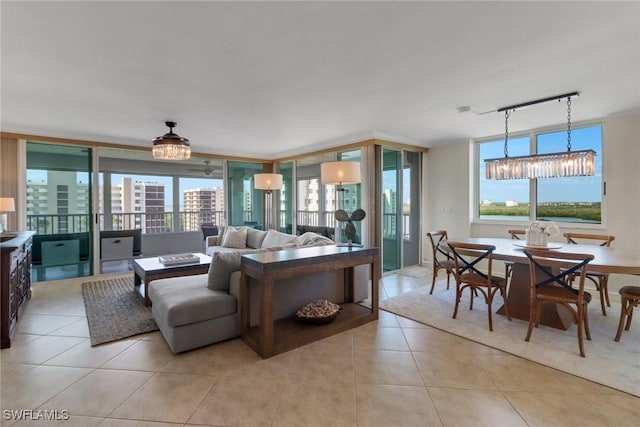 living room featuring light tile patterned floors, plenty of natural light, a chandelier, and track lighting