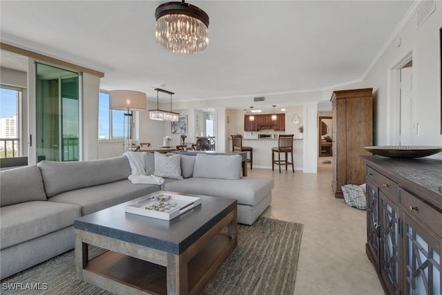 living area with light tile patterned floors, visible vents, a notable chandelier, and ornamental molding