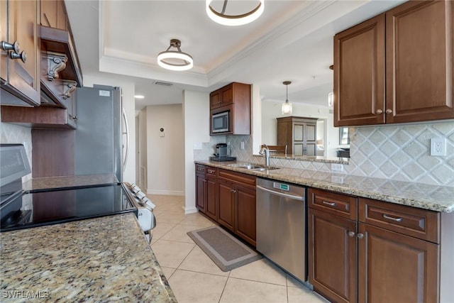 kitchen featuring light tile patterned floors, a sink, appliances with stainless steel finishes, ornamental molding, and a raised ceiling