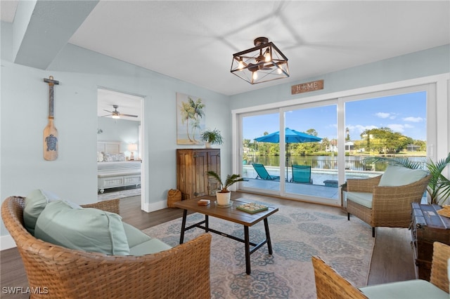 living room with baseboards, an inviting chandelier, and wood finished floors