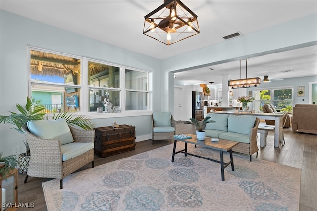 living room with an inviting chandelier, wood finished floors, and visible vents