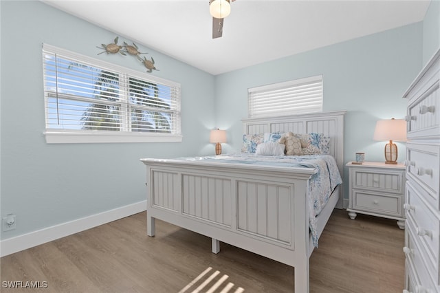 bedroom featuring dark wood-type flooring, a ceiling fan, and baseboards