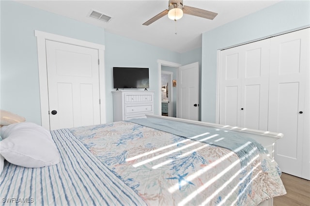 bedroom with a ceiling fan, light wood-style floors, visible vents, and a closet