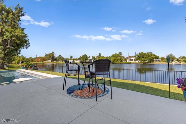 view of patio / terrace with a water view and fence