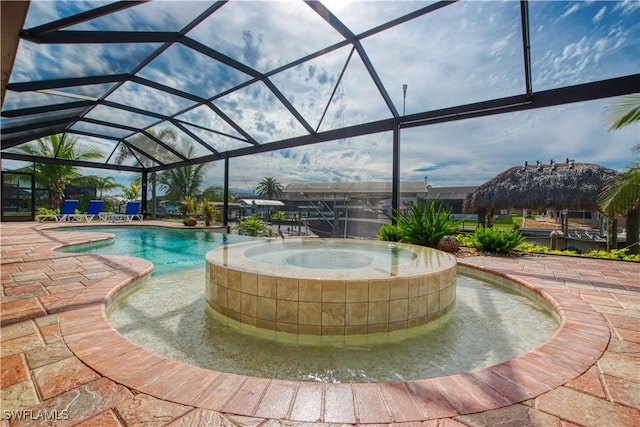 view of swimming pool with a lanai, a pool with connected hot tub, and a patio