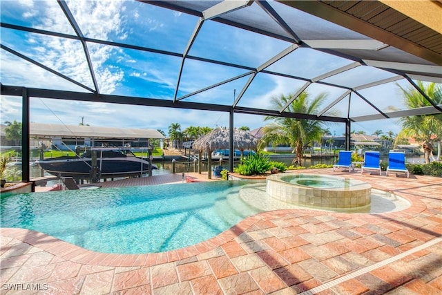 view of pool featuring glass enclosure, boat lift, a pool with connected hot tub, a boat dock, and a patio area