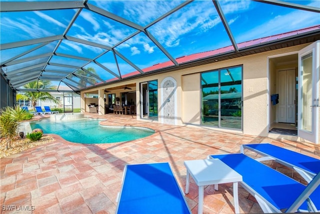 outdoor pool featuring glass enclosure, a patio area, and ceiling fan