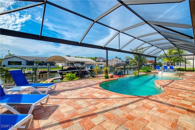 view of swimming pool with boat lift, a lanai, a pool with connected hot tub, a boat dock, and a patio area