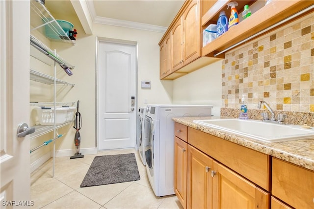 laundry room with washer and clothes dryer, light tile patterned floors, cabinet space, ornamental molding, and a sink