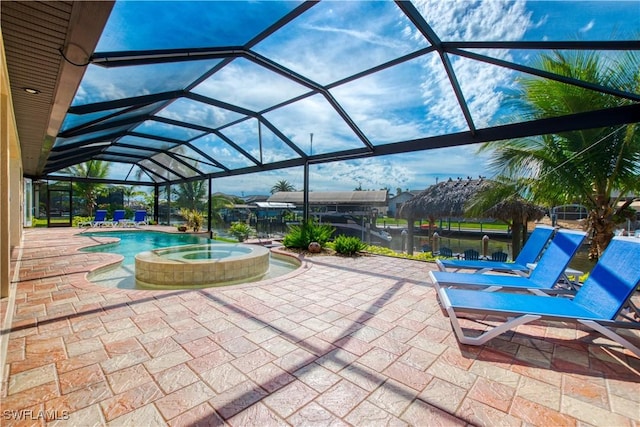 view of patio with glass enclosure and a pool with connected hot tub