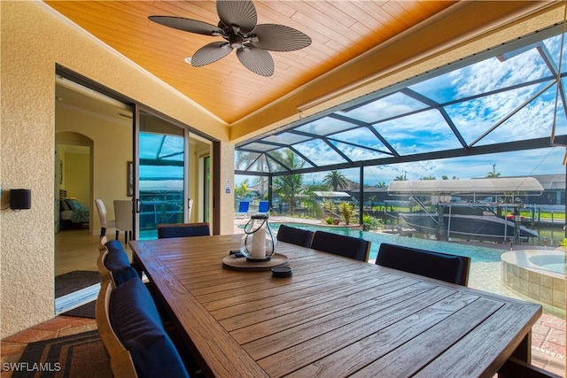 sunroom / solarium with wood ceiling and a ceiling fan